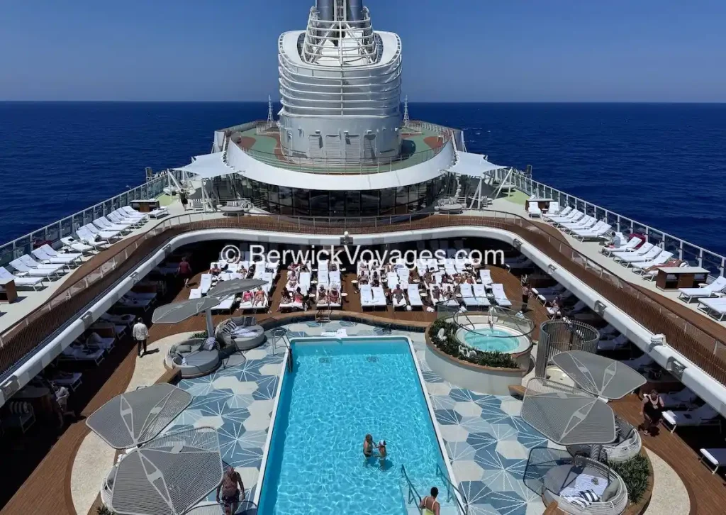 Main pool deck on Oceania Allura with central pool, hot tubs, and surrounding lounge seating